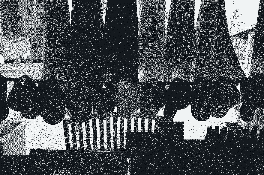 Hats and dresses silhouetted against a bright shop window