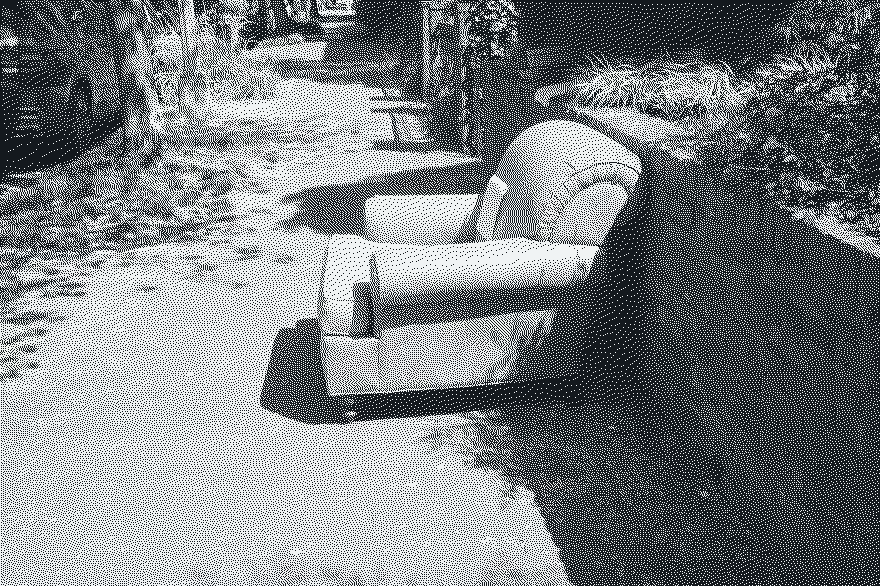 A yellow leather armchair left on a brick sidewalk